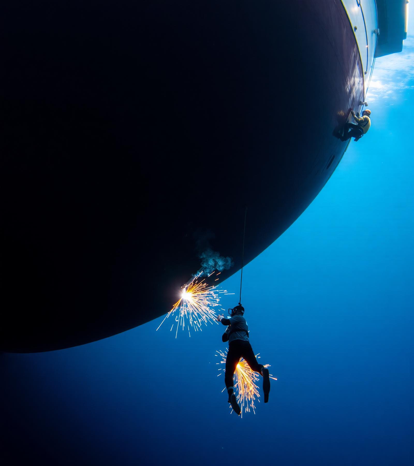 Commercial diver working on a ship hull