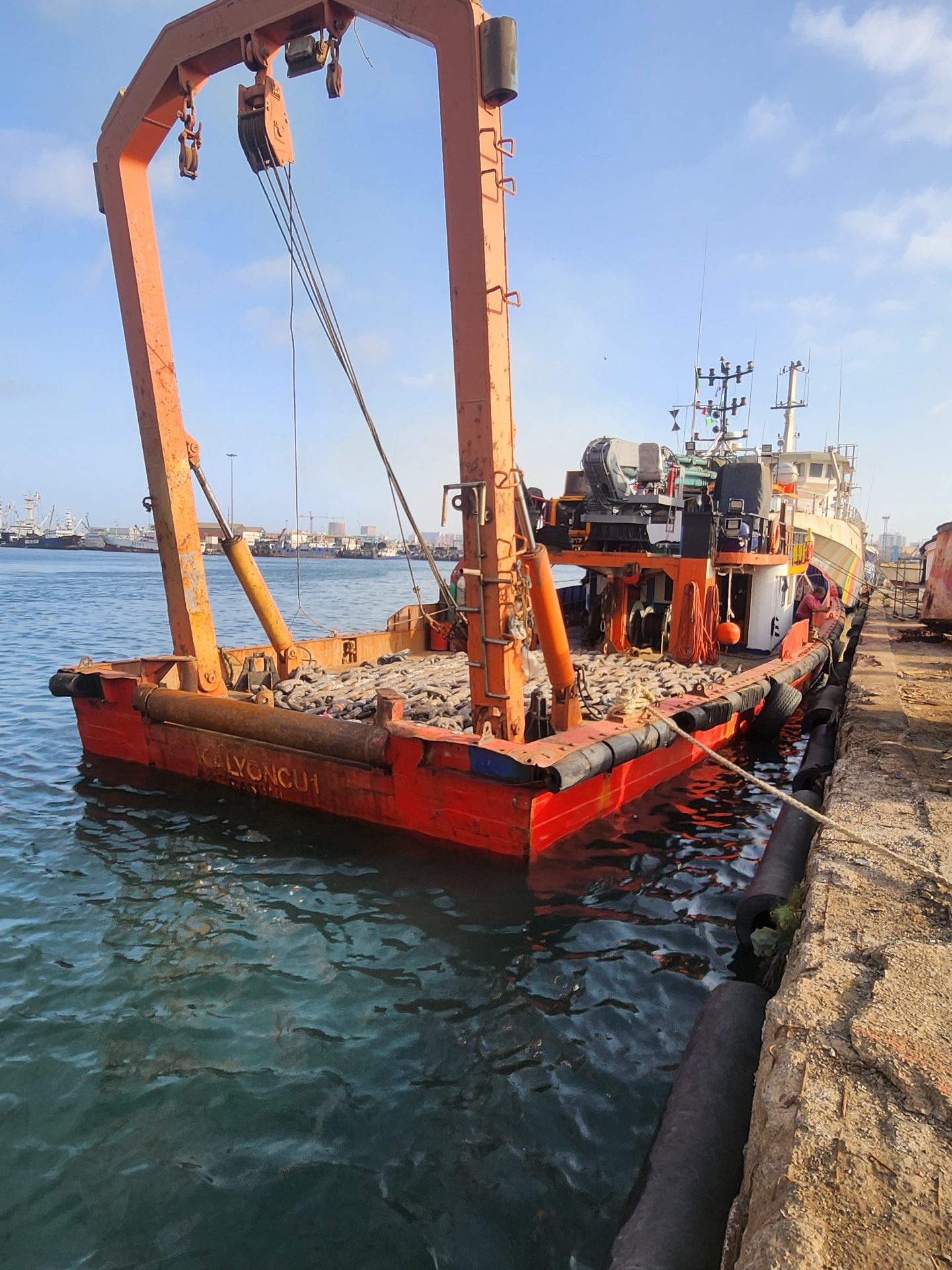 Barge loaded with heavy mooring chain at the quay